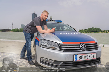 Setbesuch bei SOKO Donau - Filmset Wache am Handelskai, Wien - Di 13.07.2021 - Martin GRUBER (Portrait) mit Polizeiauto vor der Wiener Skyline 63
